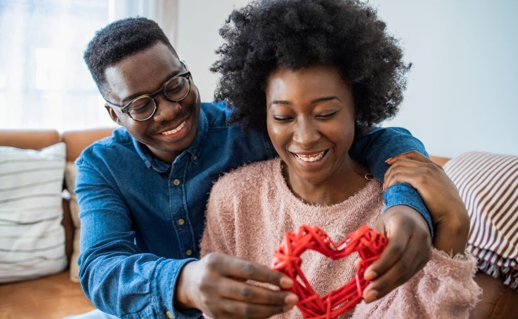 Portrait of happy African American couple holding a heart shape
