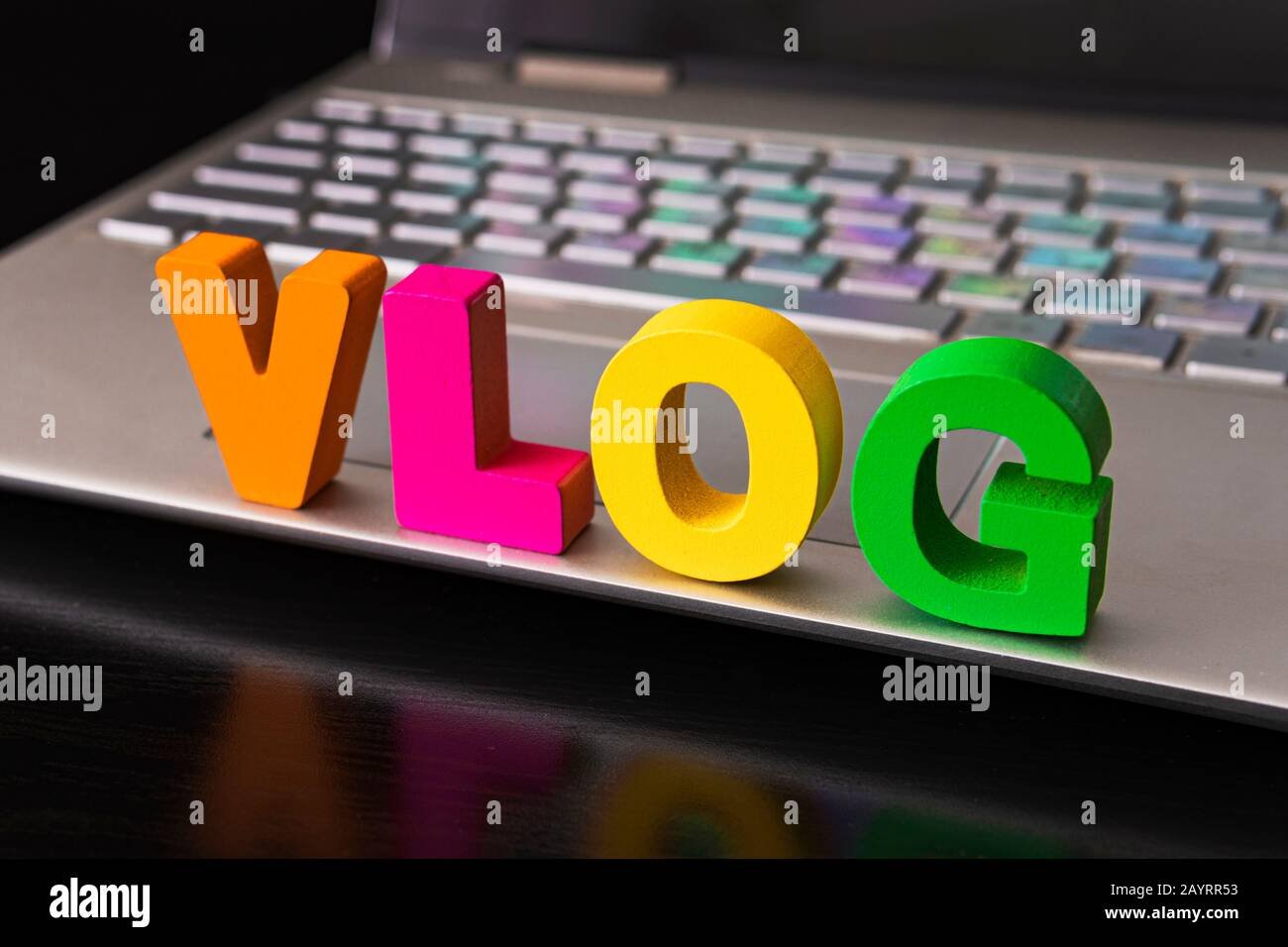 vlog-or-video-blog-concept-with-vlog-word-from-funny-letters-on-the-background-computer-keyboard-2AYRR53
