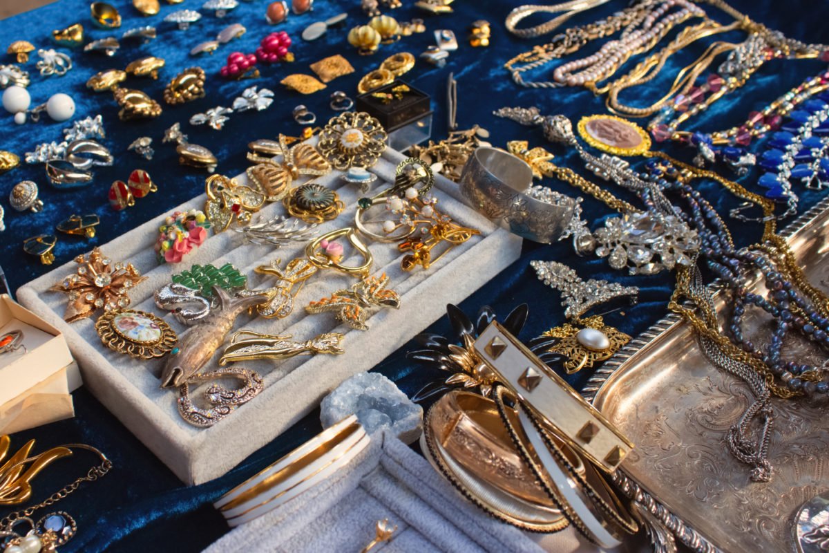 Antiques on flea market or seasonal festival – vintage jewelry, silver brooches and other vintage things. Collectibles memorabilia and garage sale concept. Selective focus